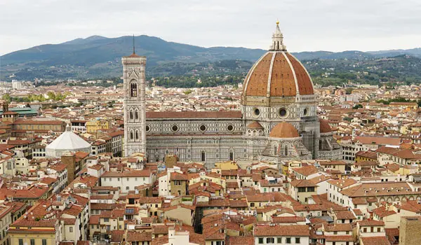 Aerial view of florence featuring the duomo with its large dome and bell tower surrounded by densely packed buildings.