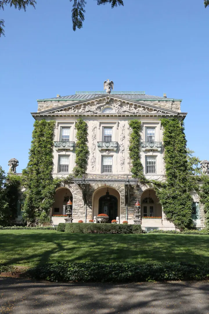 Your Guide to the Best Fall Activities Near Fairfield County, Connecticut in the month of October from pumpkin patches to haunted houses! A large, ornate building with ivy-covered walls, arched entrance, and statues on the roof, set against a clear blue sky.