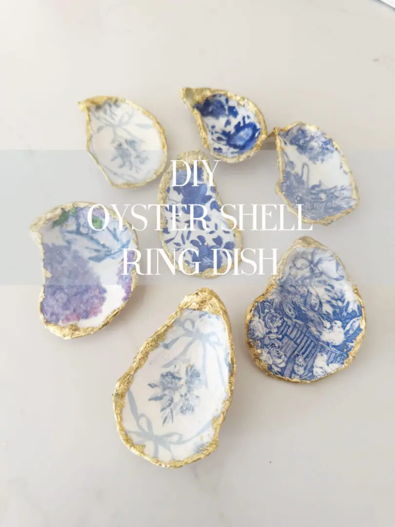 Easy DIY oyster shell ring dish using paper napkins that is a beautiful gift to give for Easter or Mother's day or make for yourself.  Seven oyster shells with blue and white patterns, edges painted in gold, are arranged on a light surface. 