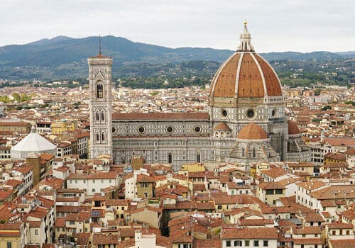 Aerial view of florence featuring the duomo with its large dome and bell tower surrounded by densely packed buildings.